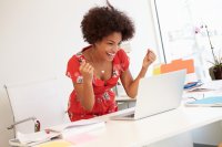 Woman cheering at laptop