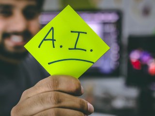 Business professional holding sticky note with Artificial Intelligence "AI" written on it