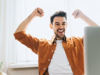 Man with arms upraised in sign of success